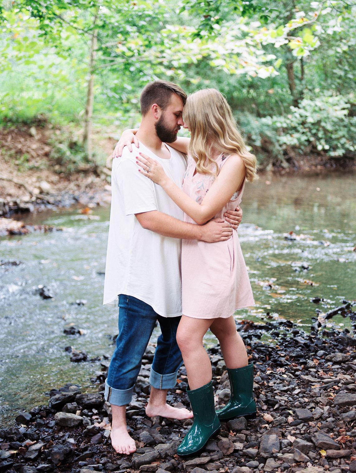 couple standing in a creek with rainboots