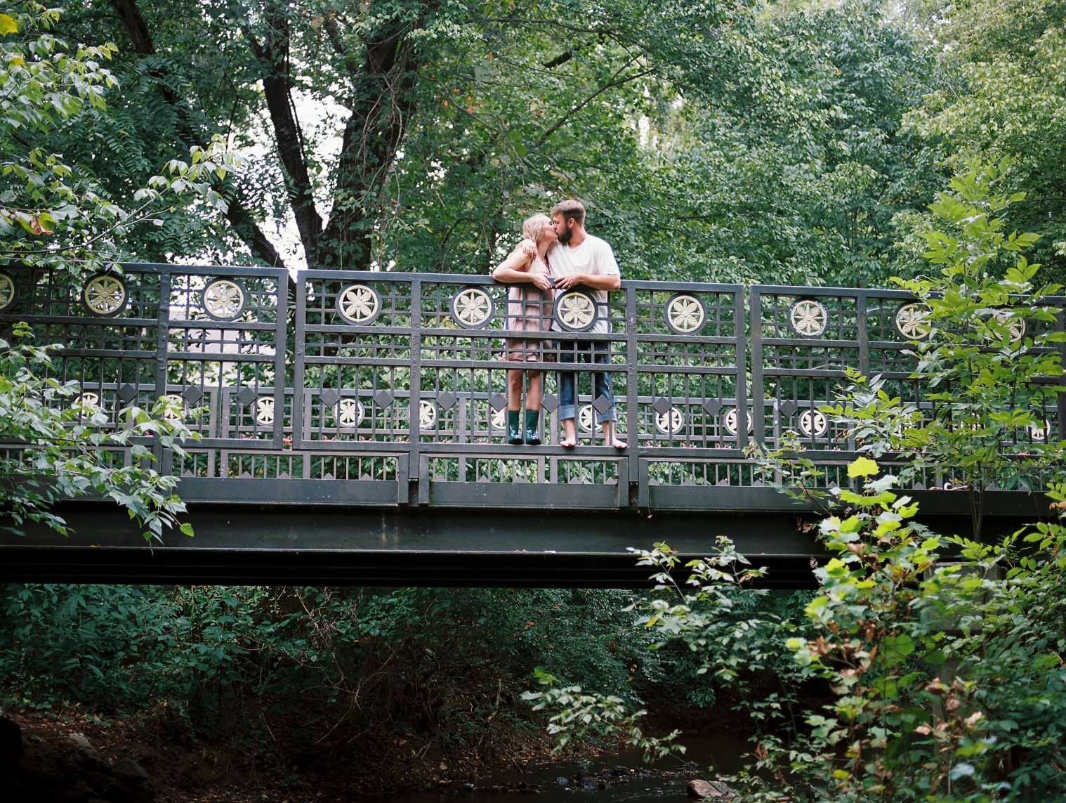 couple kissing on metal bridge